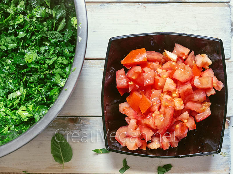 Ingredientes para hacer tabbouleh: tomates picados y perejil